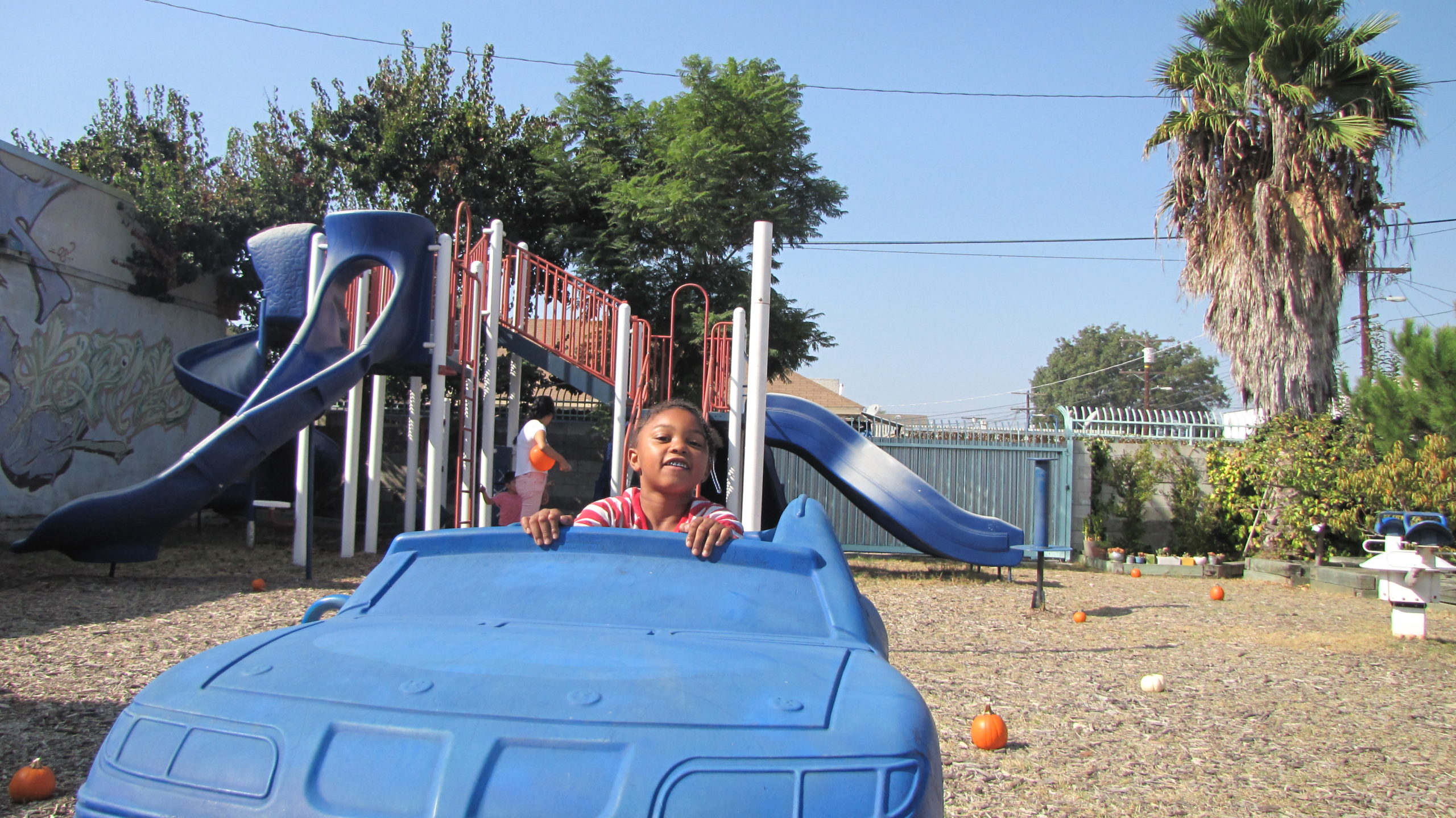 Child in a blue bar at a playground.